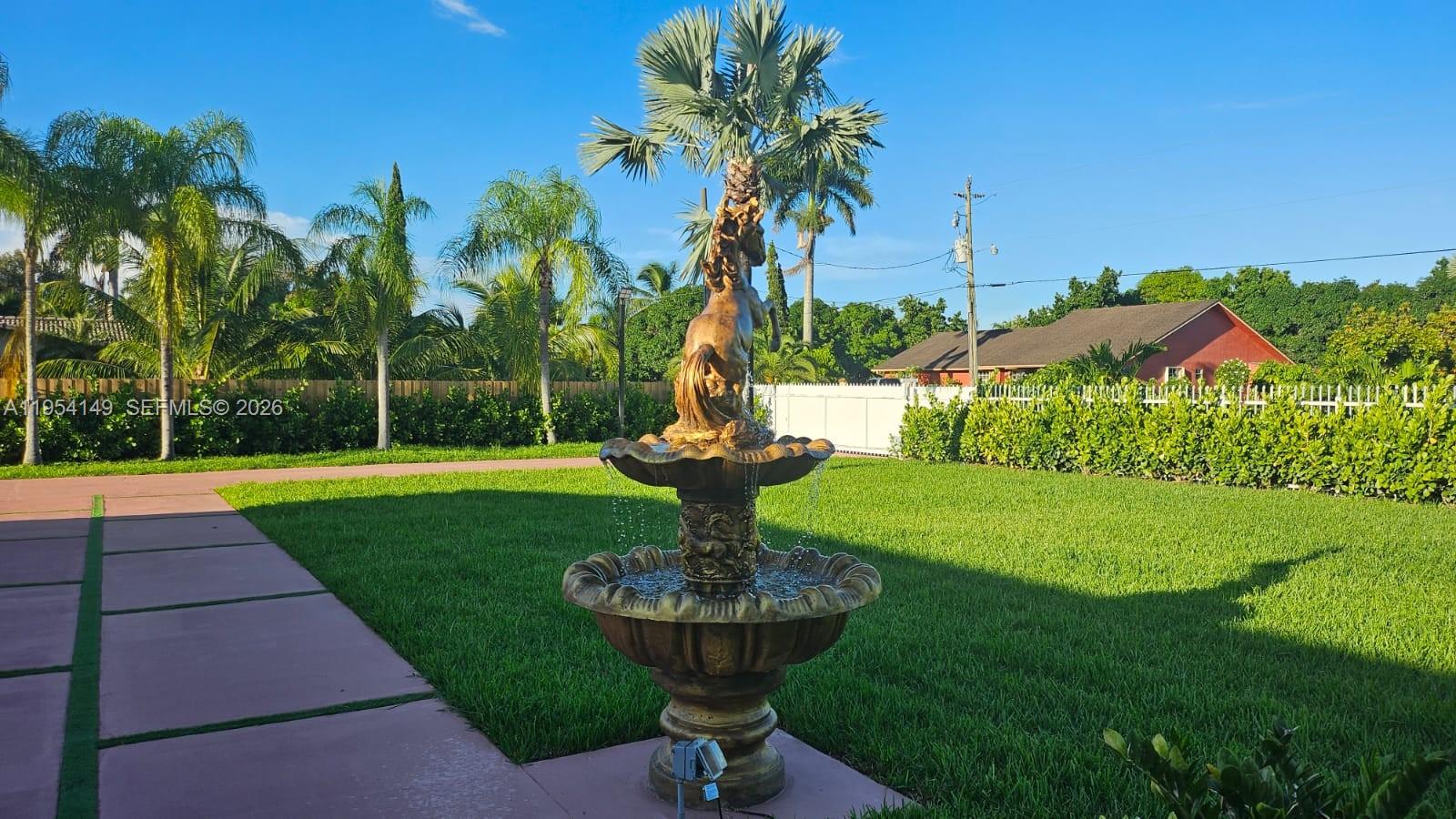 A tiered horse-themed water fountain stands in the center of a grassy backyard — 16400 SW 173rd Ave, Miami FL 33187, MIAMI, FL