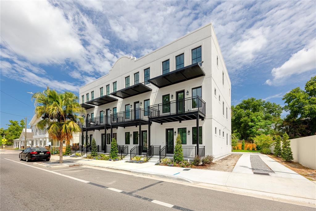 A three-story white modern townhouse building with black balconies and window frames on a street — 1308 E COLUMBUS DRIVE UNIT 2, TAMPA, FL