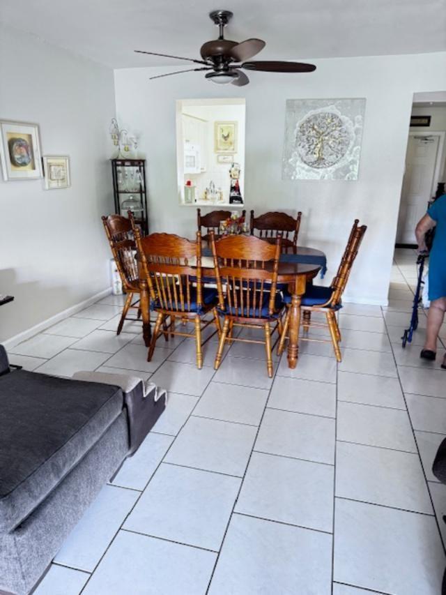 A dining area features a wooden table with six chairs, white tile flooring, and a ceiling fan — 7320 Lake Circle Drive # 407, Margate FL 33063, MARGATE, FL