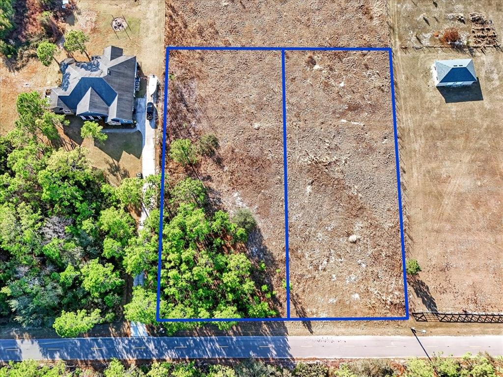 An aerial view shows two adjacent vacant rectangular lots bordered by a road and trees — SWEET HILL ROAD, POLK CITY, FL