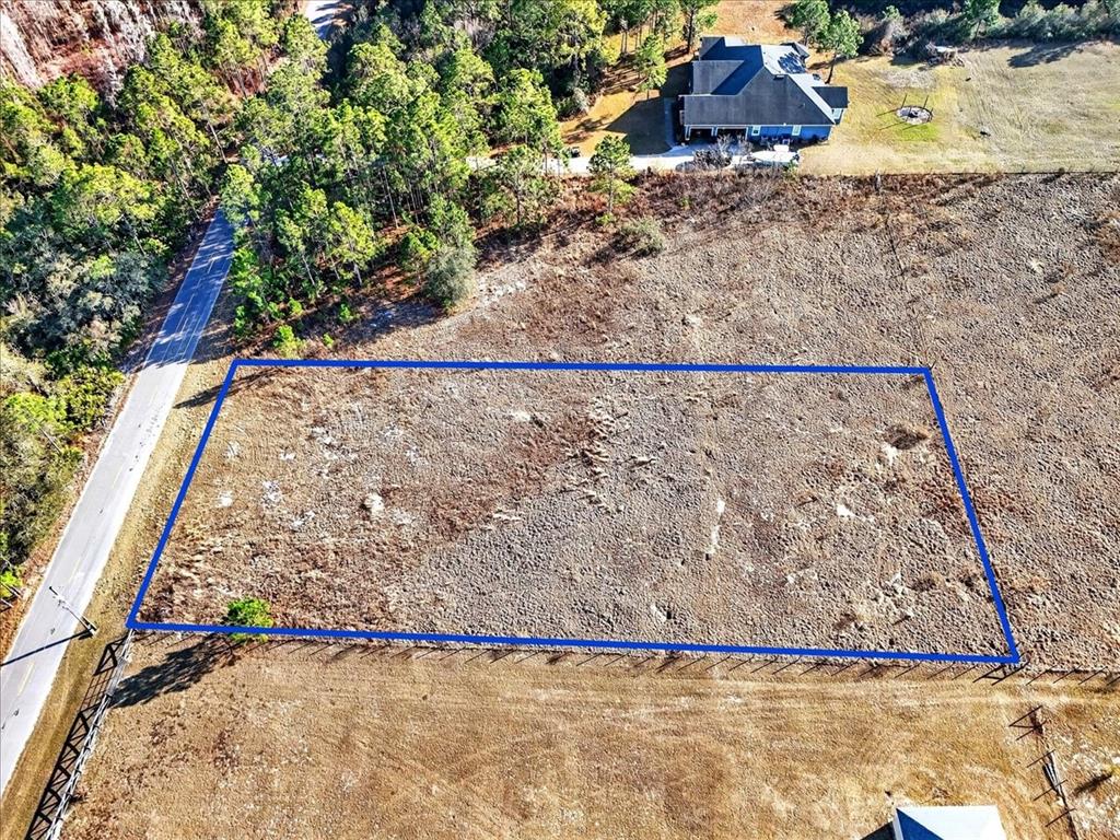 An aerial view shows a rectangular plot of land outlined in blue beside a road — SWEET HILL ROAD, POLK CITY, FL