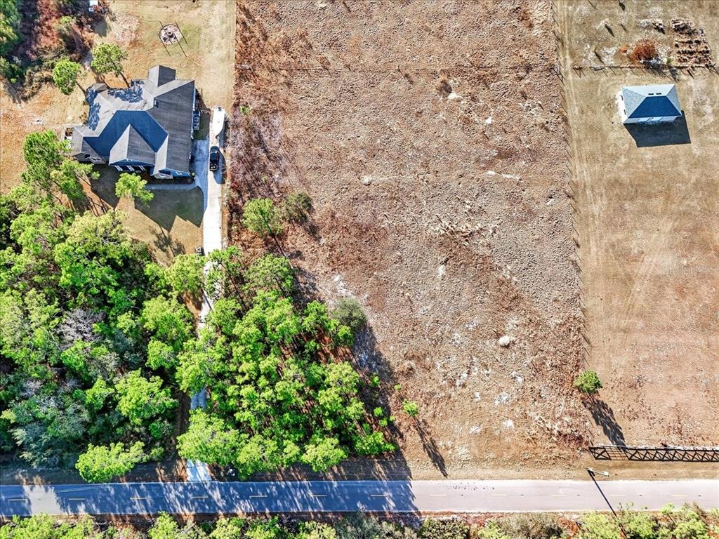 An aerial view shows a house, a cleared lot, and a small building near a road — SWEET HILL ROAD, POLK CITY, FL