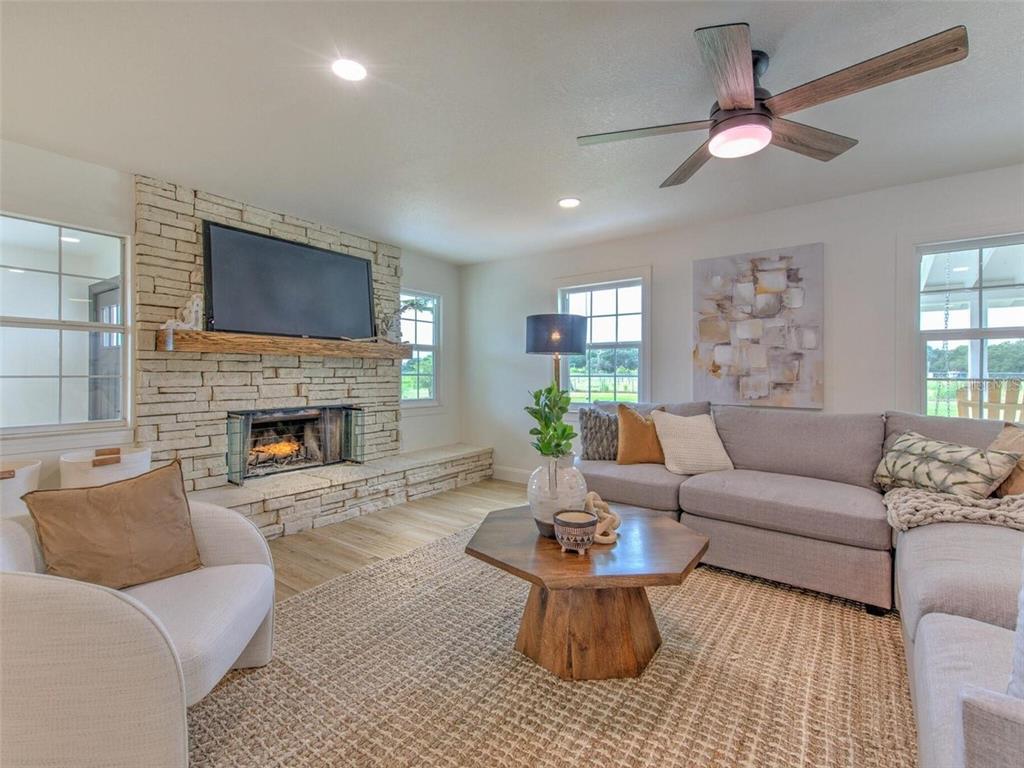 A living room features a stone fireplace, a sectional sofa, and a wooden coffee table — 4608 HOLBROOK ROAD, PLANT CITY, FL
