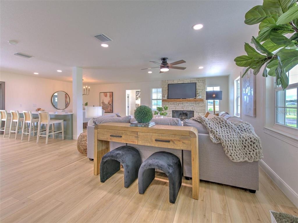A living room features a stone fireplace, a sectional sofa, and a wooden console table — 4608 HOLBROOK ROAD, PLANT CITY, FL