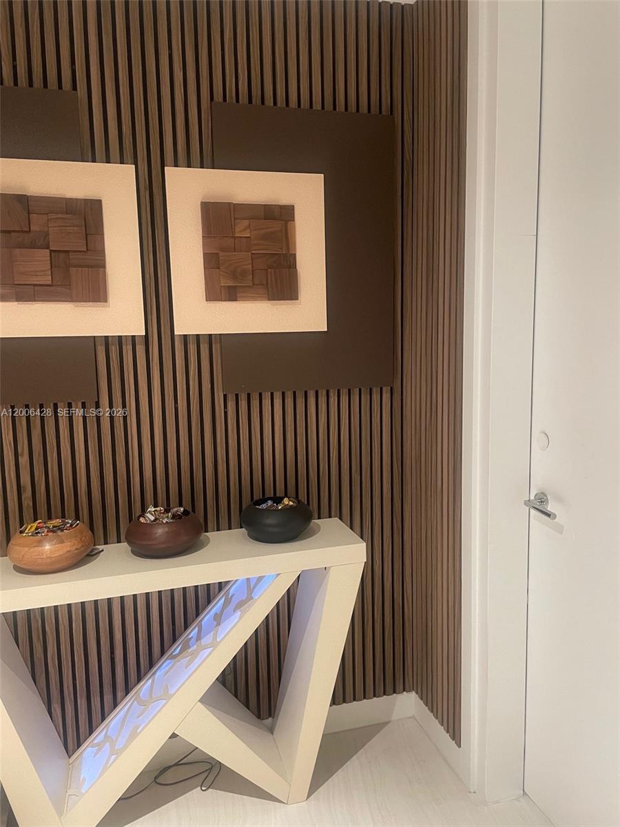 A console table with three bowls sits against a wall featuring vertical wood slats — 220 SE Mizner Blvd # 321, Boca Raton FL 33432, BOCA RATON, FL