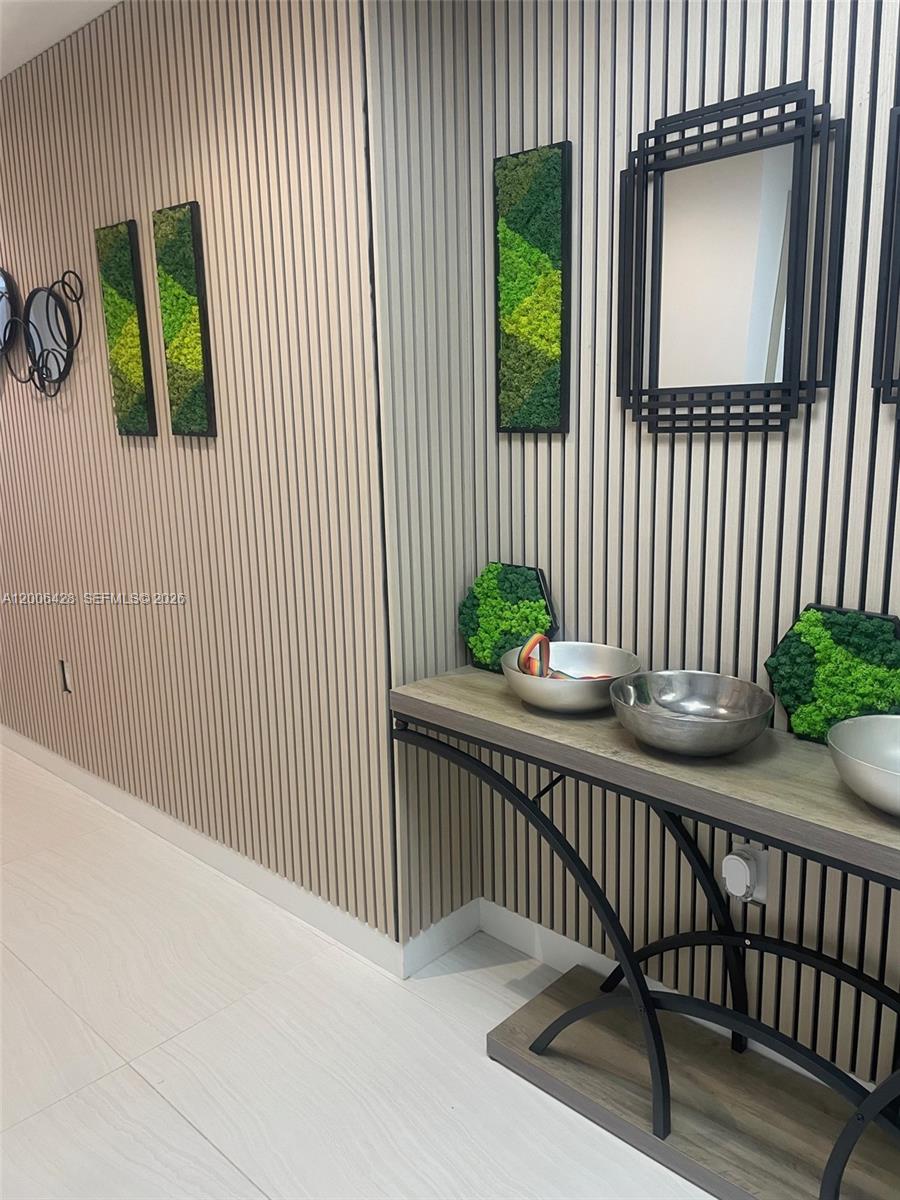 A hallway features light wood-slat walls, a console table with metal bowls, and moss art — 220 SE Mizner Blvd # 321, Boca Raton FL 33432, BOCA RATON, FL