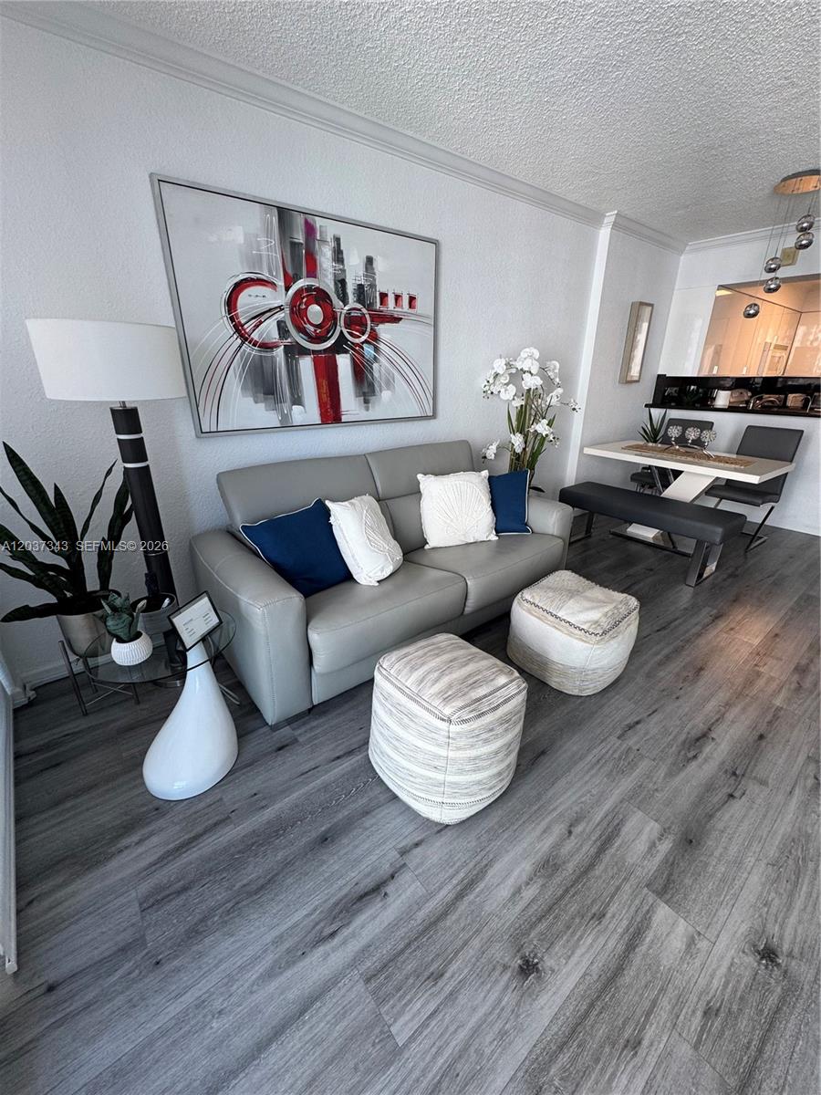 A living room features a gray sofa, two ottomans, and a dining area with benches — 2501 S Ocean Dr # 1105, Hollywood FL 33019, HOLLYWOOD, FL