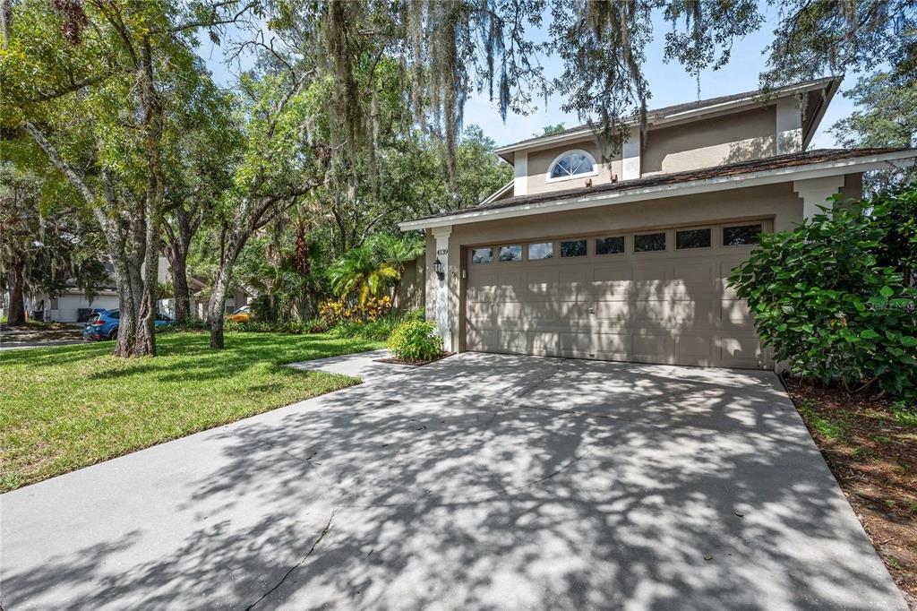 A two-story house with a beige exterior, a two-car garage, and a concrete driveway — 4139 MORELAND DRIVE, VALRICO, FL