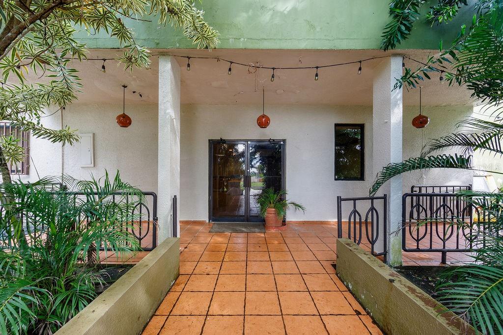 A covered patio with orange tile flooring leads to a glass double-door entrance — 690 LOS NABORIAS STREET, VEGA ALTA, PR