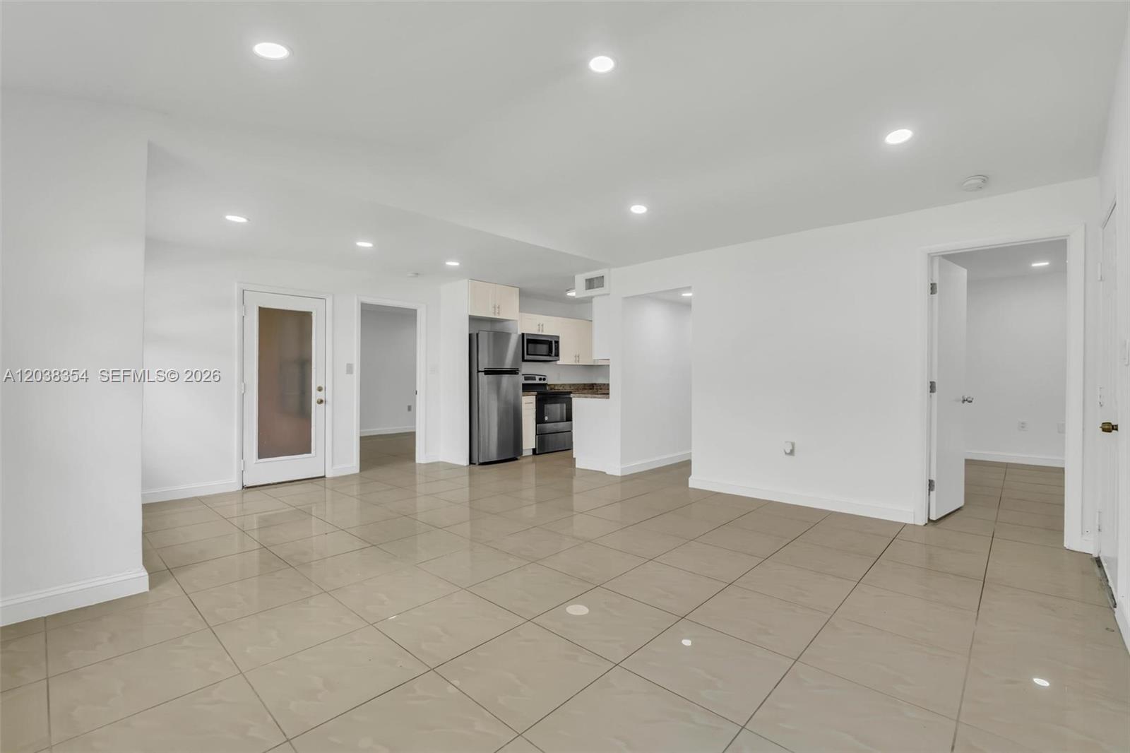 An open-concept living area features white walls, recessed lighting, and large beige floor tiles — 15560 SW 104th Ter # 6112, Miami FL 33196, MIAMI, FL