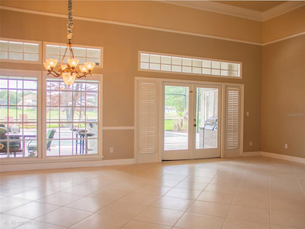 A bright living room features tile floors, a chandelier, and glass doors leading outside — 600 CHOCKTAW STREET, LAKE MARY, FL