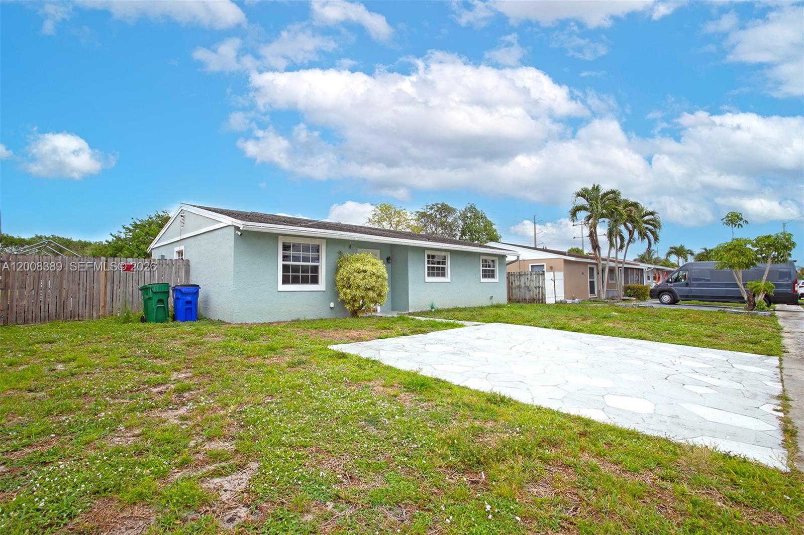 A light blue, single-story house features a stone driveway and a wooden fence — 7471 SW 1st St, Margate FL 33068, MARGATE, FL