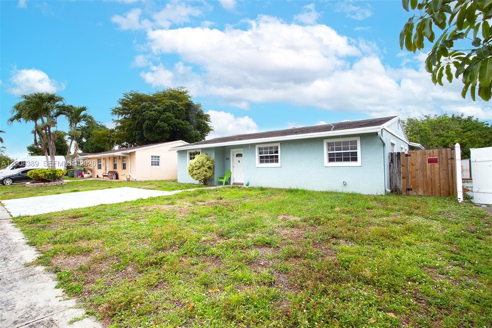 A light blue, single-story house with a front lawn and a wooden fence — 7471 SW 1st St, Margate FL 33068, MARGATE, FL