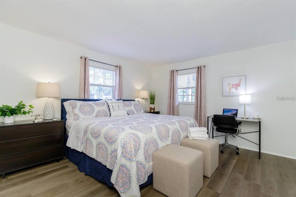 A bedroom features a king bed, a desk with a chair, and wood-look flooring — 1297 13TH STREET, SARASOTA, FL