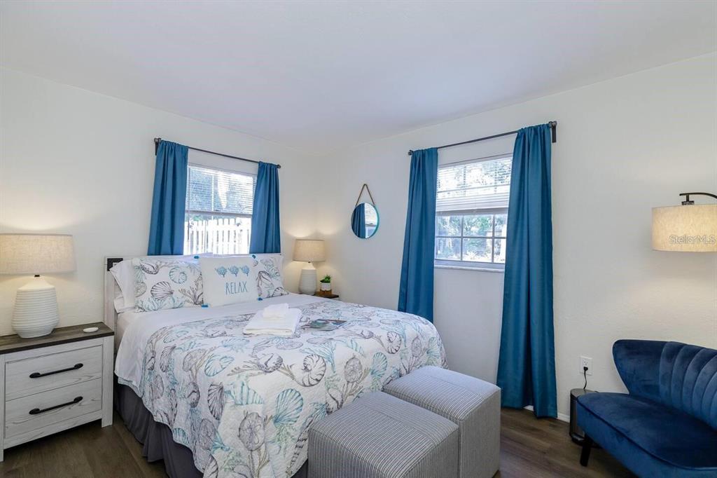 A bedroom features a bed with a seashell quilt, blue curtains, and a blue chair — 1297 13TH STREET, SARASOTA, FL