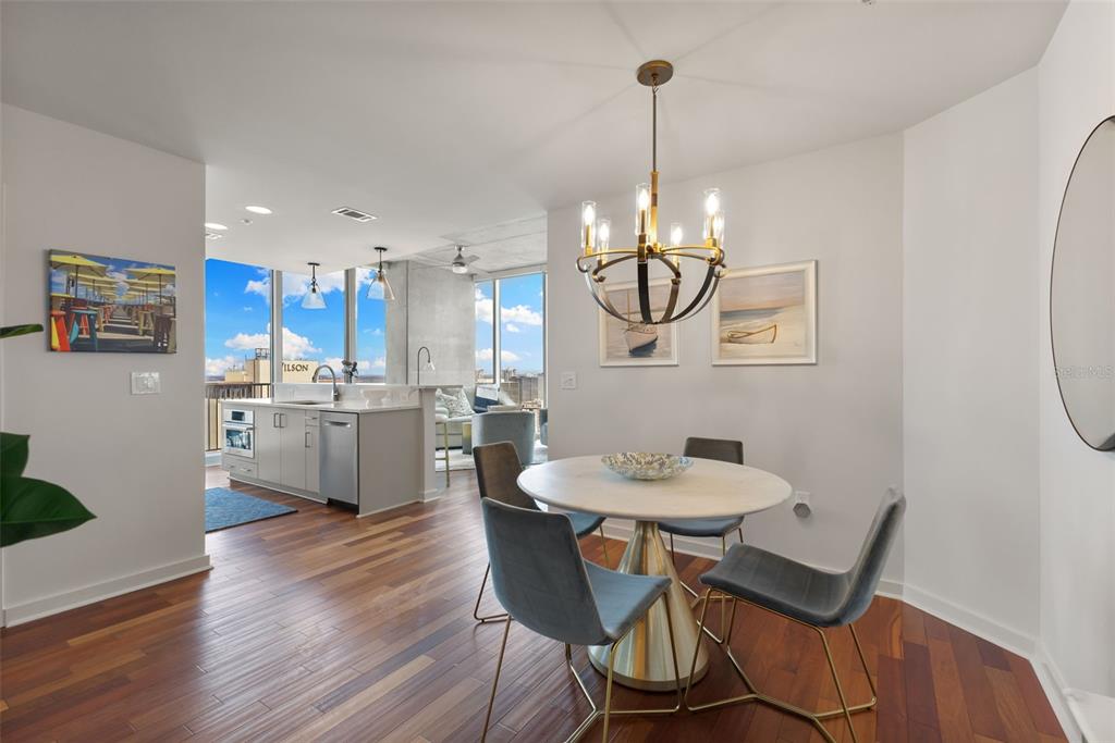 A dining area with a round table and chandelier opens into a modern kitchen — 777 N ASHLEY DRIVE UNIT 2514, TAMPA, FL