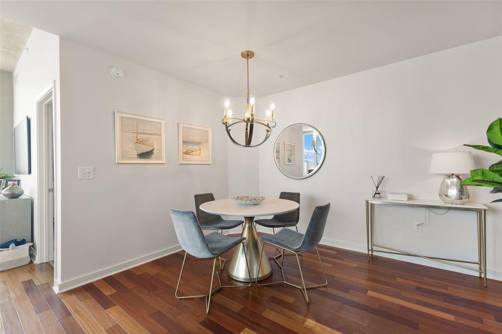 A dining area features a round table, four blue chairs, and a gold chandelier — 777 N ASHLEY DRIVE UNIT 2514, TAMPA, FL