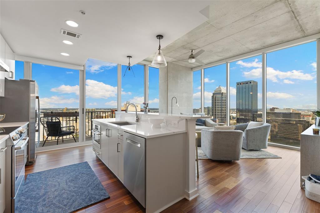A modern kitchen with a central island overlooks a city skyline through floor-to-ceiling windows — 777 N ASHLEY DRIVE UNIT 2514, TAMPA, FL