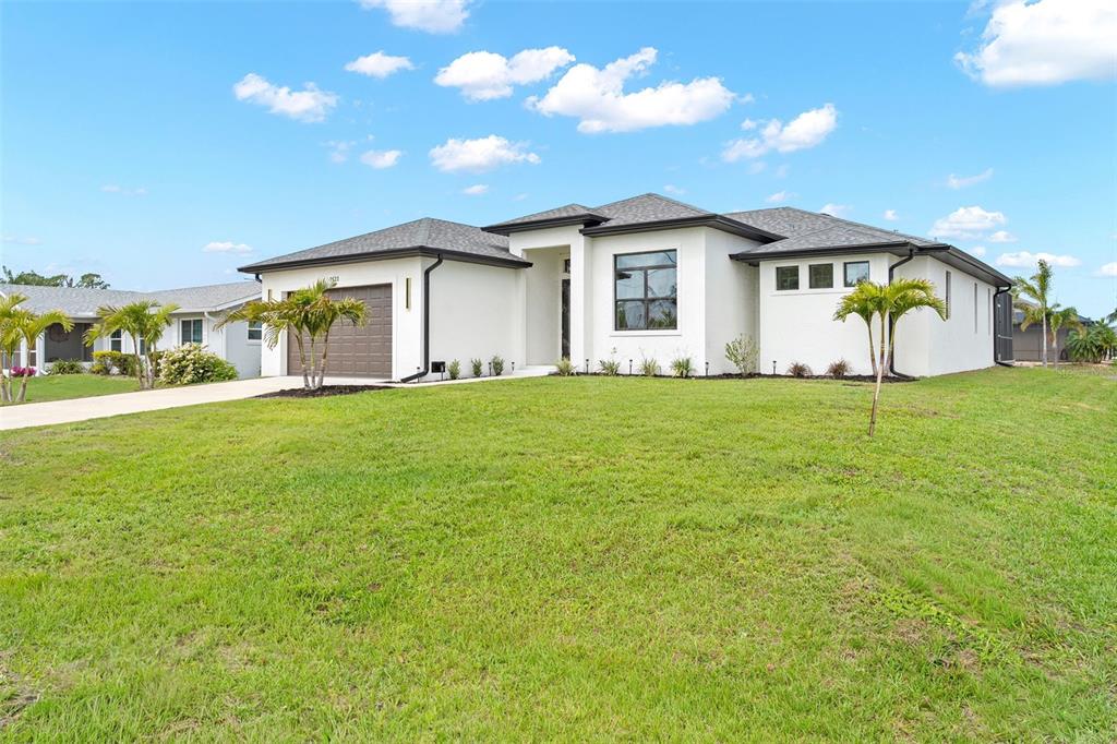A modern white single-story house with a brown garage and a green lawn — 2523 DIXON TERRACE, PORT CHARLOTTE, FL