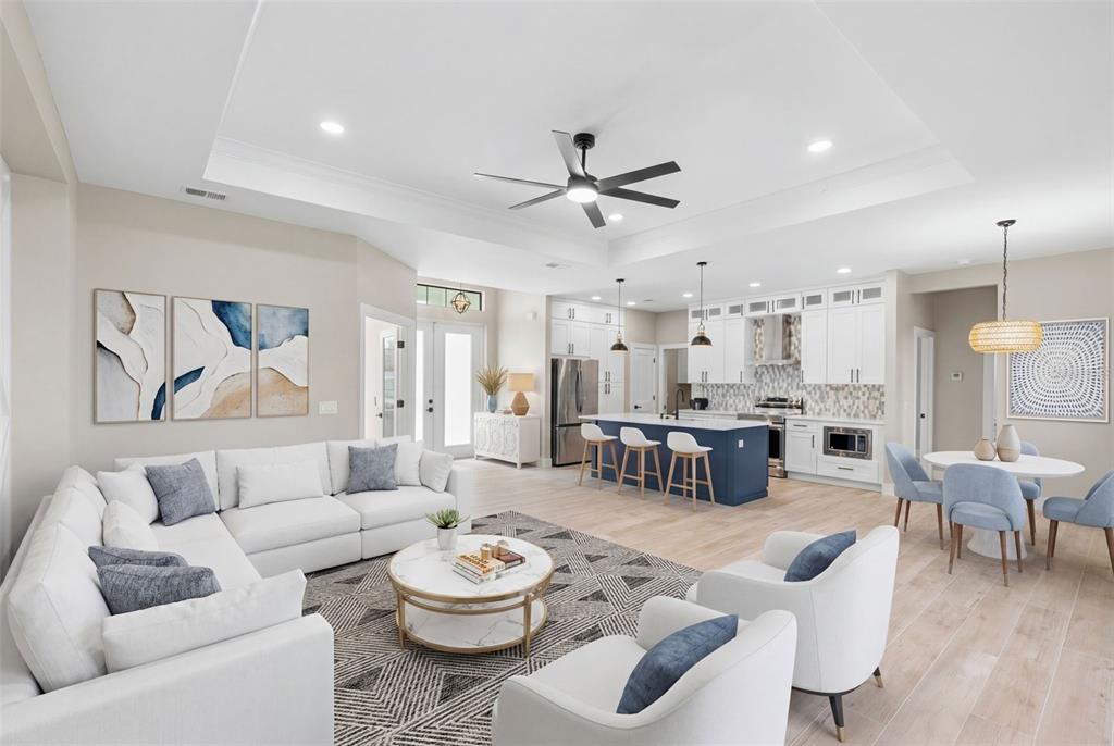 An open-concept living room and kitchen featuring white cabinetry, a blue island, and light flooring — 2523 DIXON TERRACE, PORT CHARLOTTE, FL