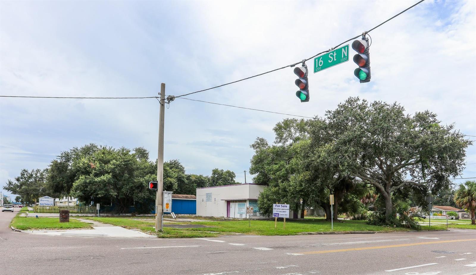 A corner lot with a small commercial building, mature trees, and a traffic light intersection — 1246 N 16th Street, FL 33705, FL