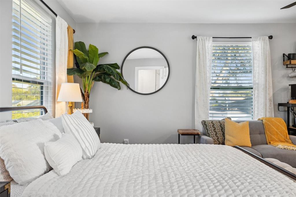A bathroom with a wood vanity, open shelving, and a view into a bedroom — 4015 10TH AVENUE N UNIT B, ST PETERSBURG, FL