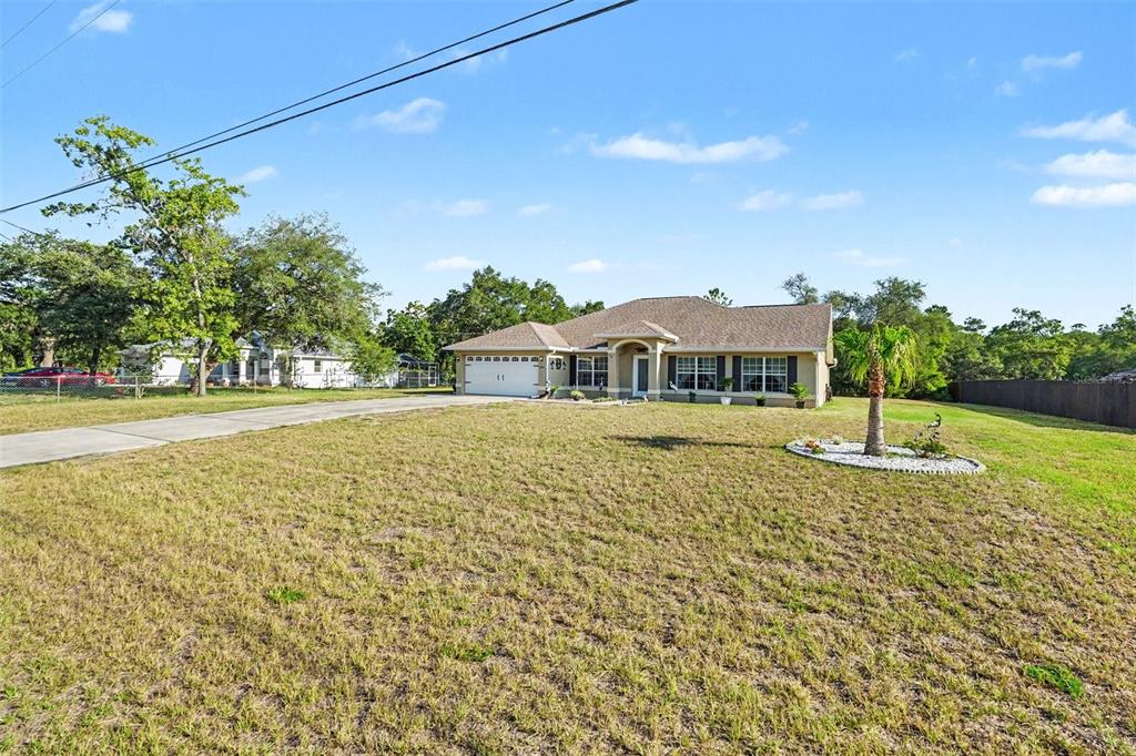 A dining area features a round table, four chairs, a chandelier, and a front door — 11177 MIRAGE AVENUE, BROOKSVILLE, FL