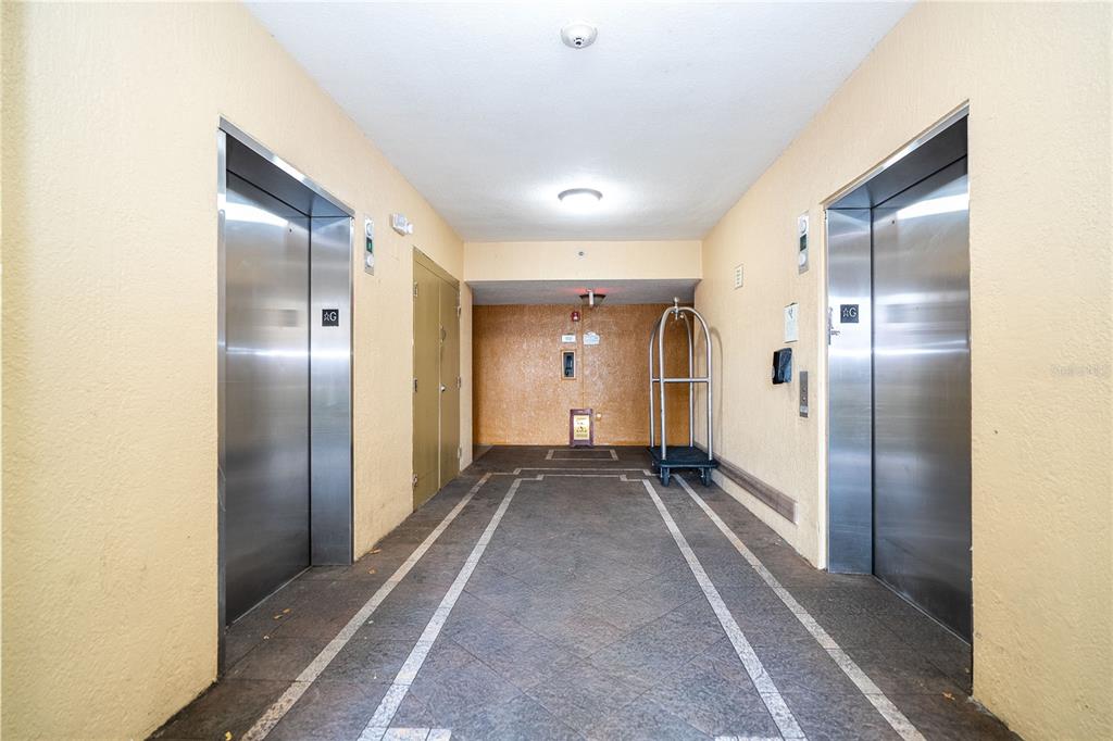 An elevator lobby features two stainless steel doors, tiled flooring, and a luggage cart — 12527 FLORIDAYS RESORT DRIVE UNIT 611-E, ORLANDO, FL