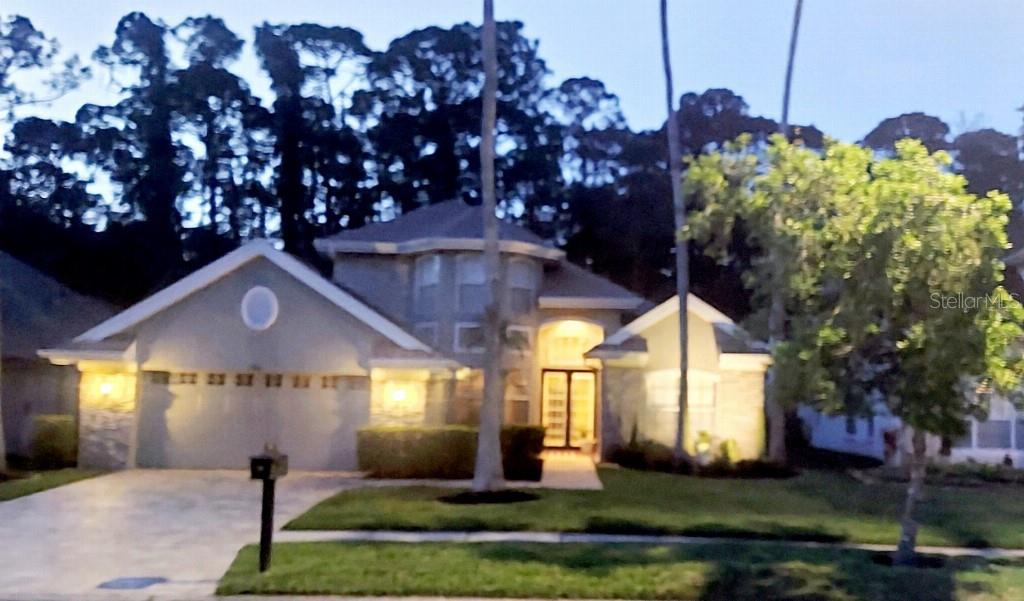 A single-story house with a stone facade, gray stucco, and a paved walkway — 9820 GRETNA GREEN DRIVE, TAMPA, FL