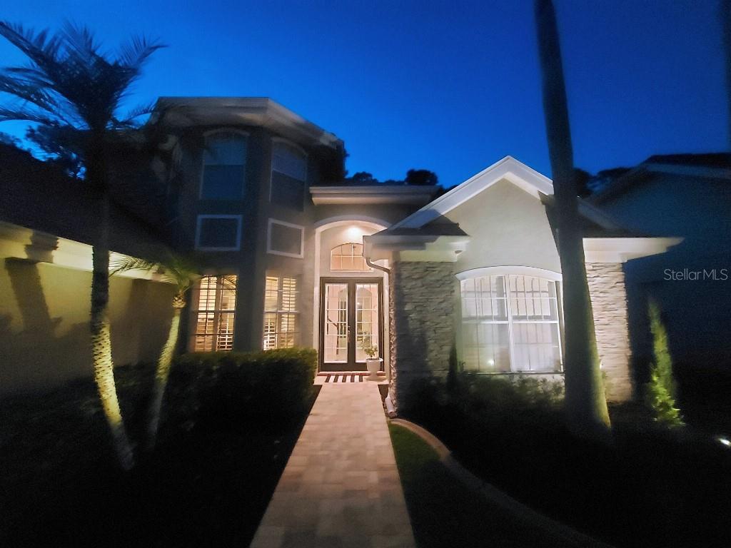 A two-story suburban house with a stone facade, a paved walkway, and a garage — 9820 GRETNA GREEN DRIVE, TAMPA, FL
