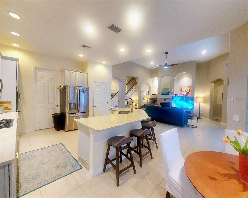 A bright entryway features tile flooring, a chandelier, and a staircase leading to the living area — 9820 GRETNA GREEN DRIVE, TAMPA, FL