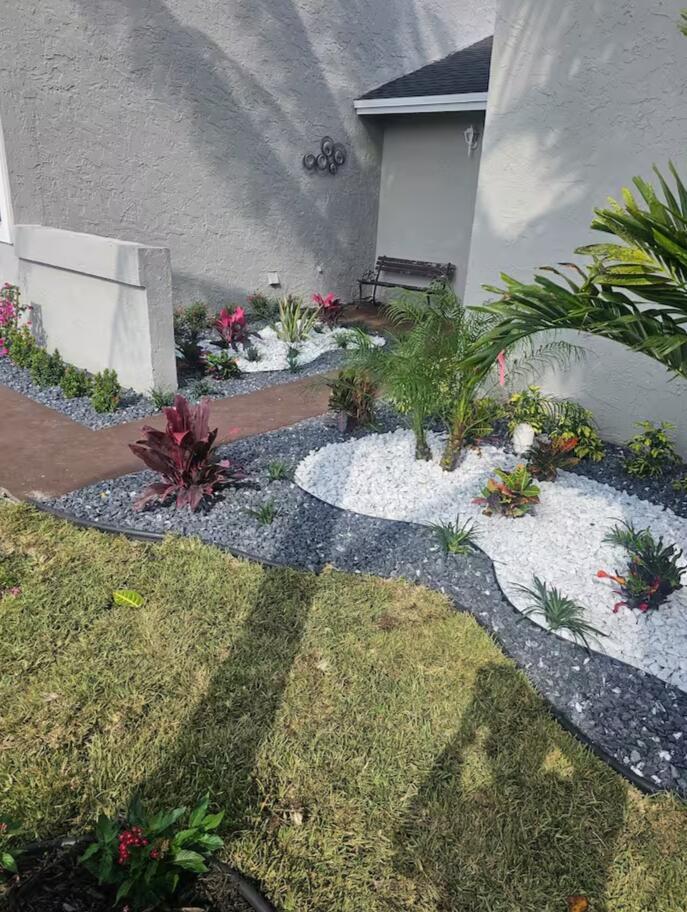 A landscaped front yard features white and grey decorative rocks, tropical plants, and a walkway — 750 SW 55th Avenue, Margate FL 33068, MARGATE, FL