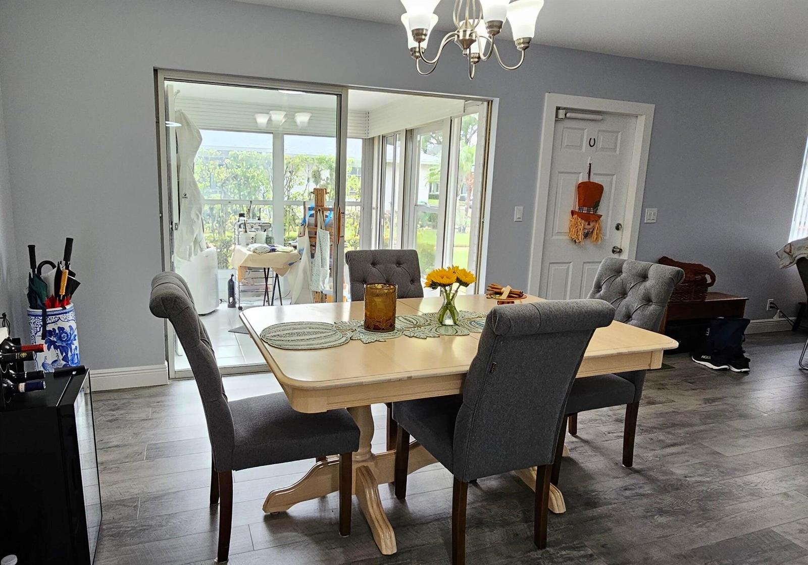 A dining room features a light wood table, gray upholstered chairs, and a sliding glass door — 10126 S 44th Terrace S, Boynton Beach FL 33436, BOYNTON BEACH, FL