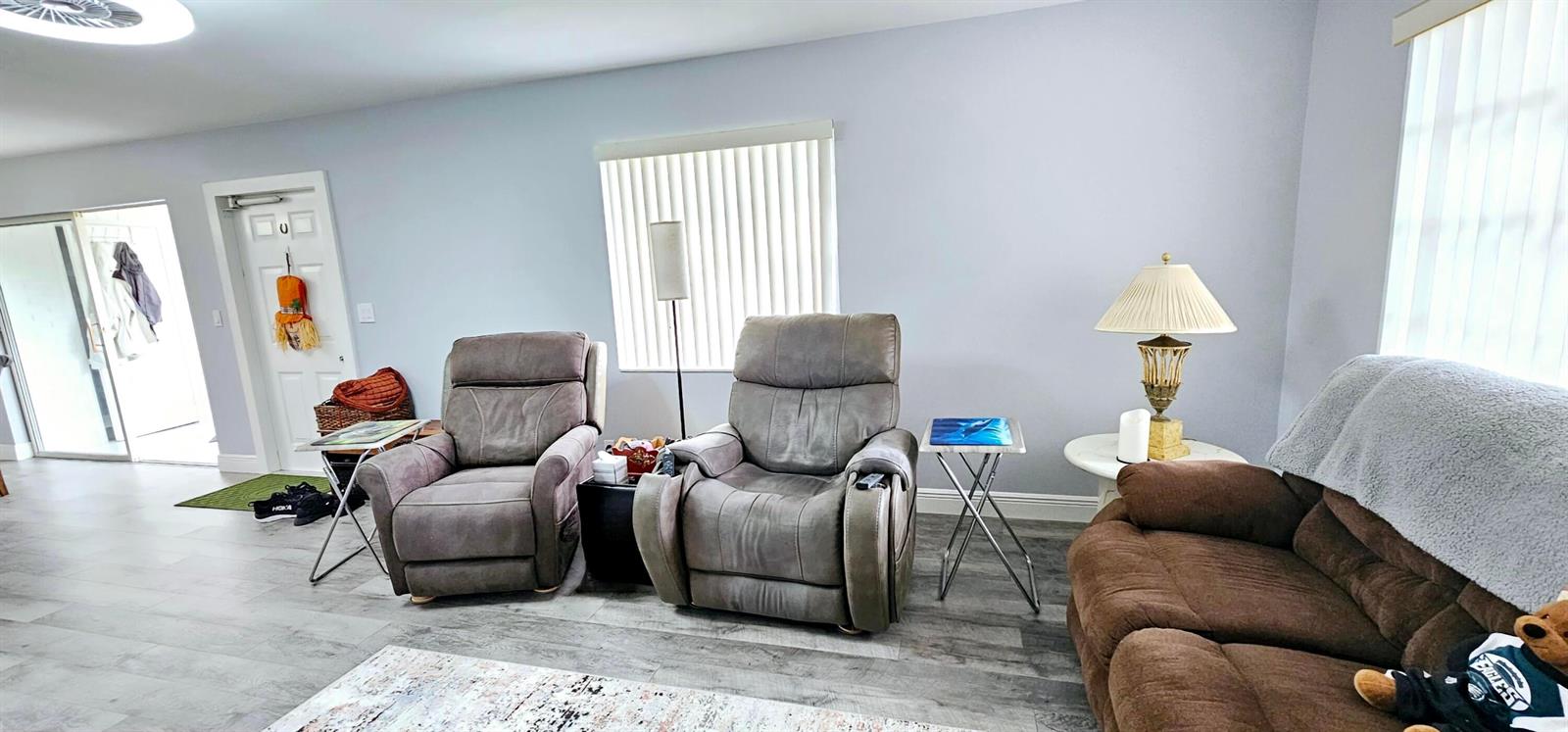 A living room features two grey recliners, a brown sofa, and light wood-look flooring — 10126 S 44th Terrace S, Boynton Beach FL 33436, BOYNTON BEACH, FL