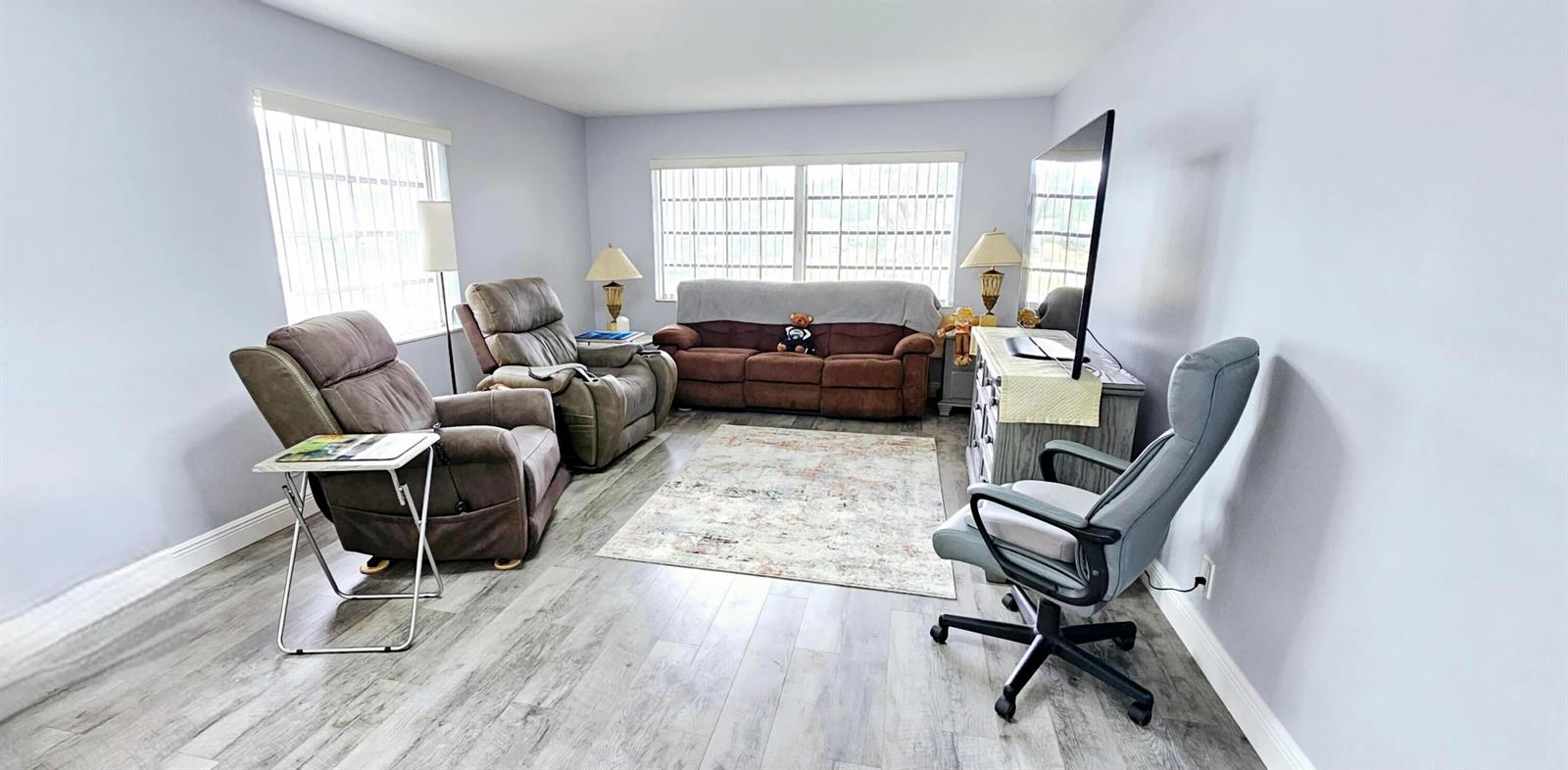 A living room features gray wood-look flooring, two brown recliners, a sofa, and a desk chair — 10126 S 44th Terrace S, Boynton Beach FL 33436, BOYNTON BEACH, FL