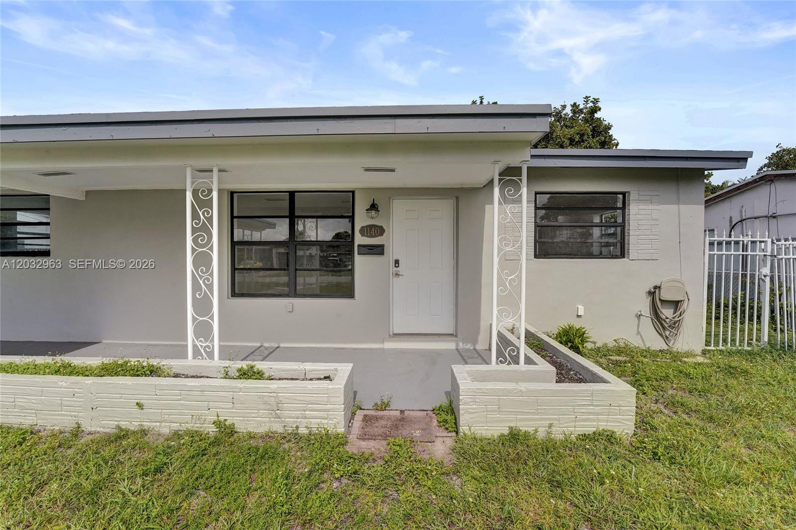 The exterior of a single-story house features a covered porch with decorative metal columns — 1140 N 74th Way, Hollywood FL 33024, HOLLYWOOD, FL