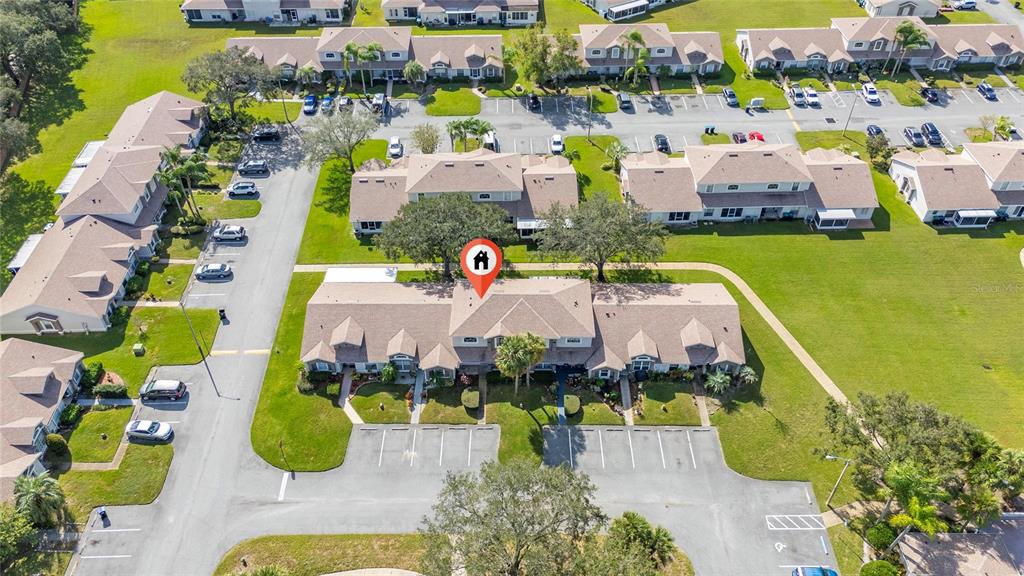 An aerial view shows a multi-unit residential building with a brown roof and parking lot — 1220 GARDEN ISLE COURT, ORLANDO, FL