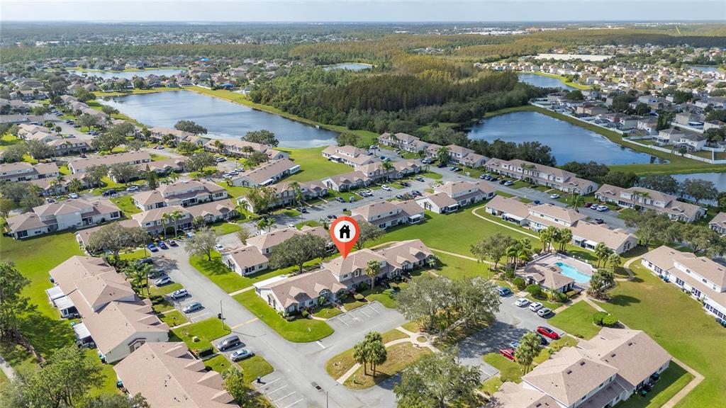 An aerial view shows a residential community with townhomes, parking lots, and two large ponds — 1220 GARDEN ISLE COURT, ORLANDO, FL