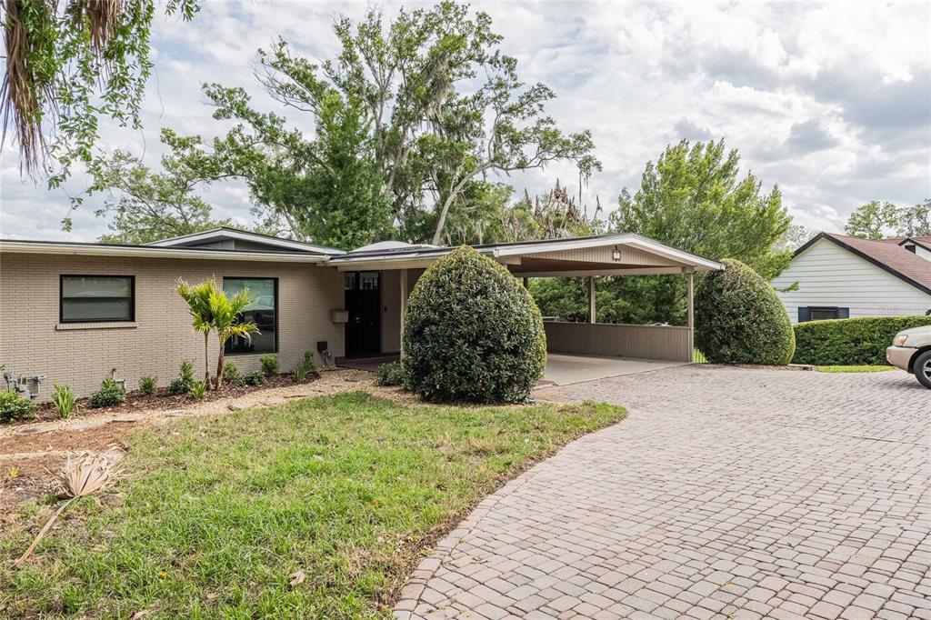 A single-story brick house features a large carport and a paved driveway — 7 LAKE HOLLINGSWORTH DRIVE, LAKELAND, FL
