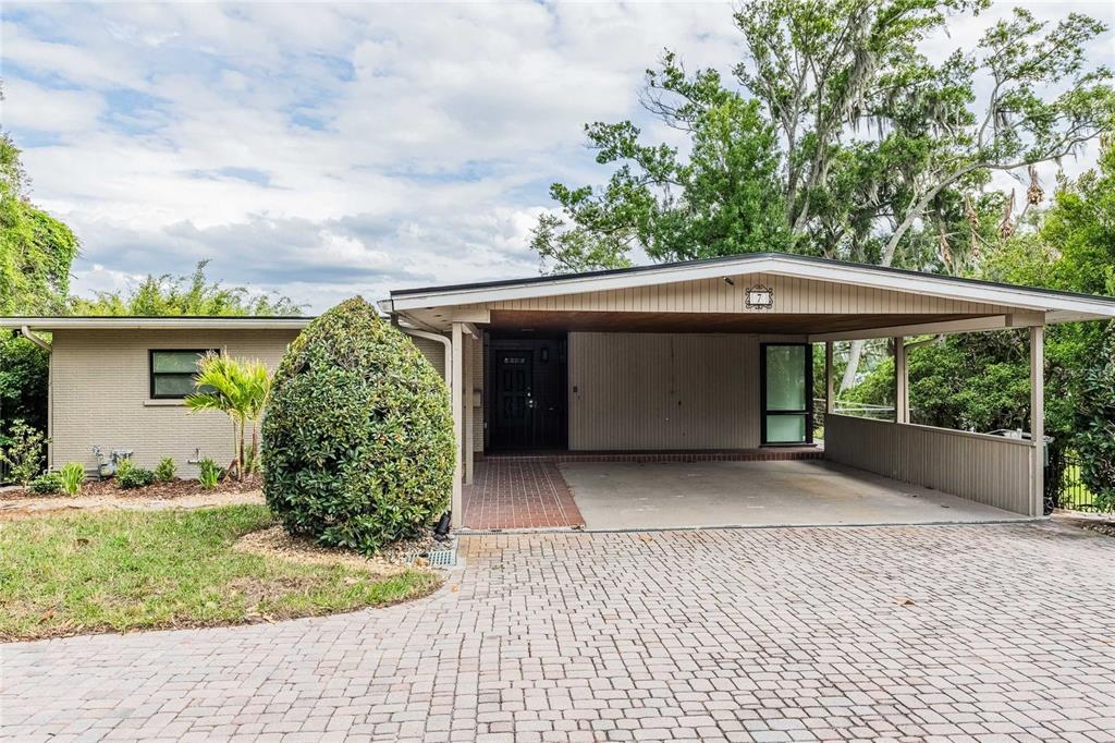 A single-story house features a brick exterior, a large carport, and a paved driveway — 7 LAKE HOLLINGSWORTH DRIVE, LAKELAND, FL