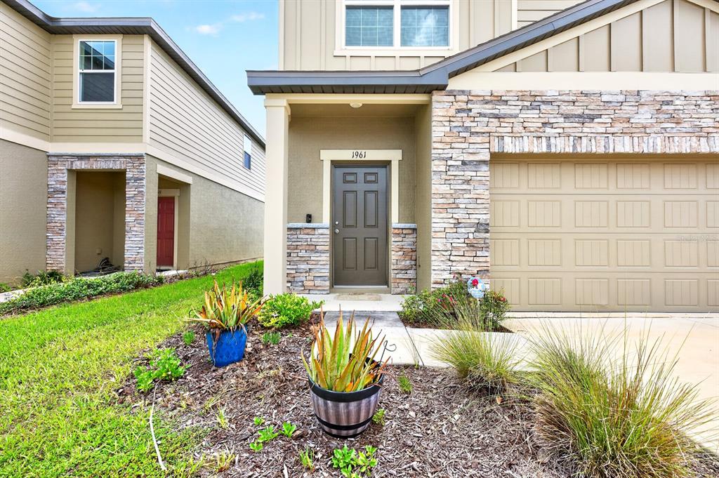The exterior of a two-story house features a stone facade, garage, and front entrance — 1961 HEMINGWAY CIRCLE, GROVELAND, FL