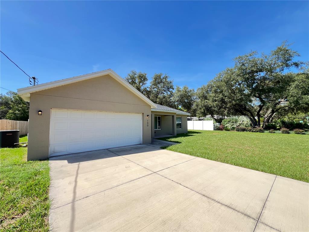 A single-story house with a beige exterior, a two-car garage, and a concrete driveway — 190 FISHER WAY, OCKLAWAHA, FL