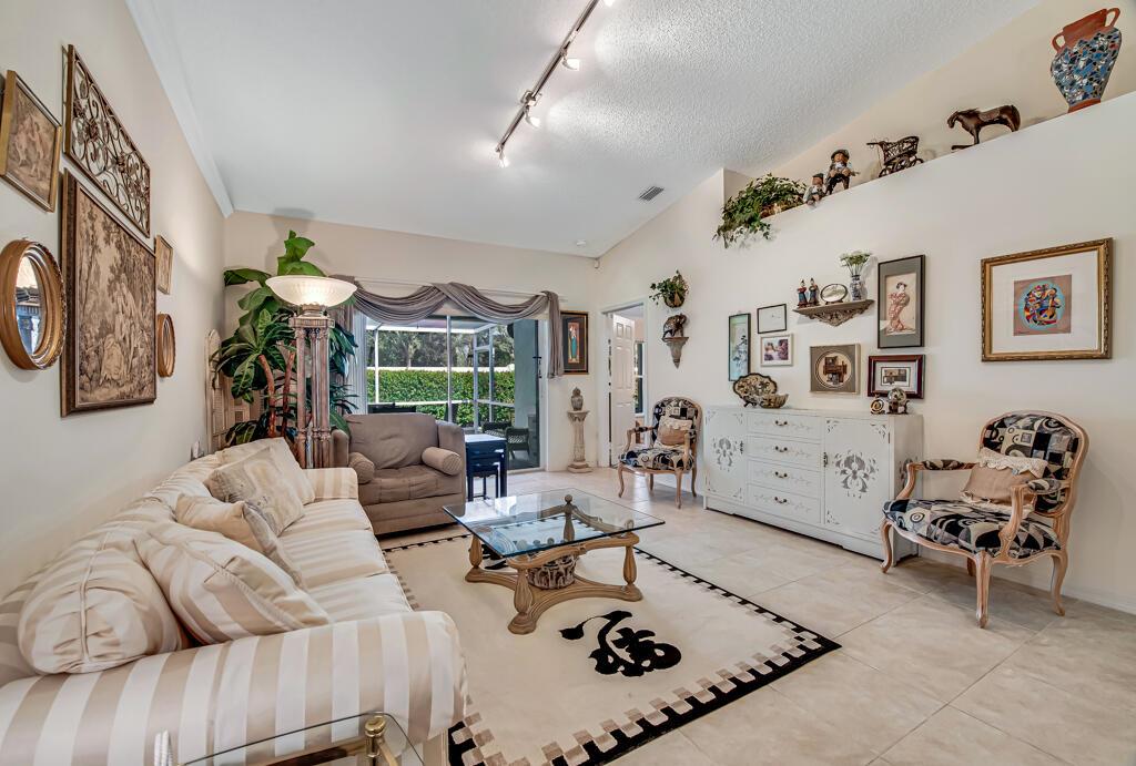 A dining area with tile flooring, a pass-through window, a pendant light, and white doors — 8482 Logia Circle, Boynton Beach FL 33472, BOYNTON BEACH, FL