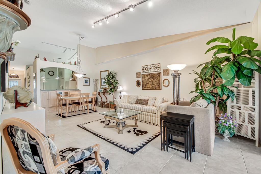 A dining area with tile floors, a light wood built-in cabinet, and a hanging pendant light — 8482 Logia Circle, Boynton Beach FL 33472, BOYNTON BEACH, FL