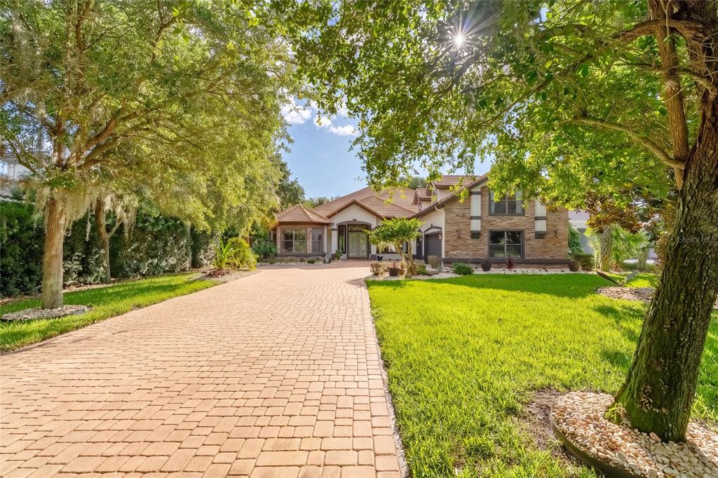 A large house with a stone facade and a long brick paver driveway — 3 FLAGSHIP COURT, PALM COAST, FL