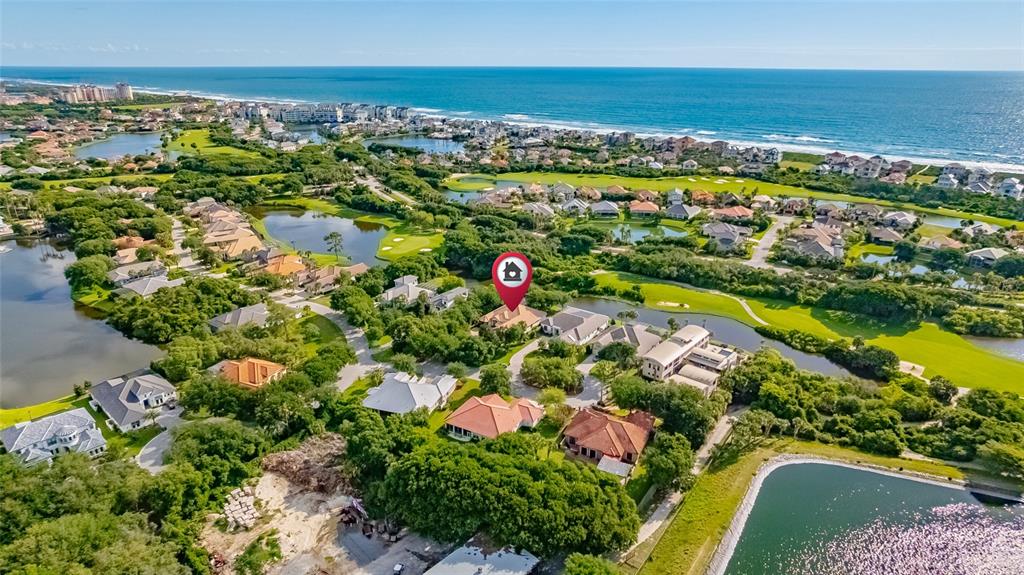 An aerial view shows a residential neighborhood with houses, ponds, and a golf course — 3 FLAGSHIP COURT, PALM COAST, FL