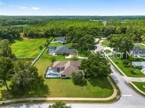 An aerial view shows a suburban house with a pool and large yard near trees — 5060 SE 40TH STREET, OCALA, FL