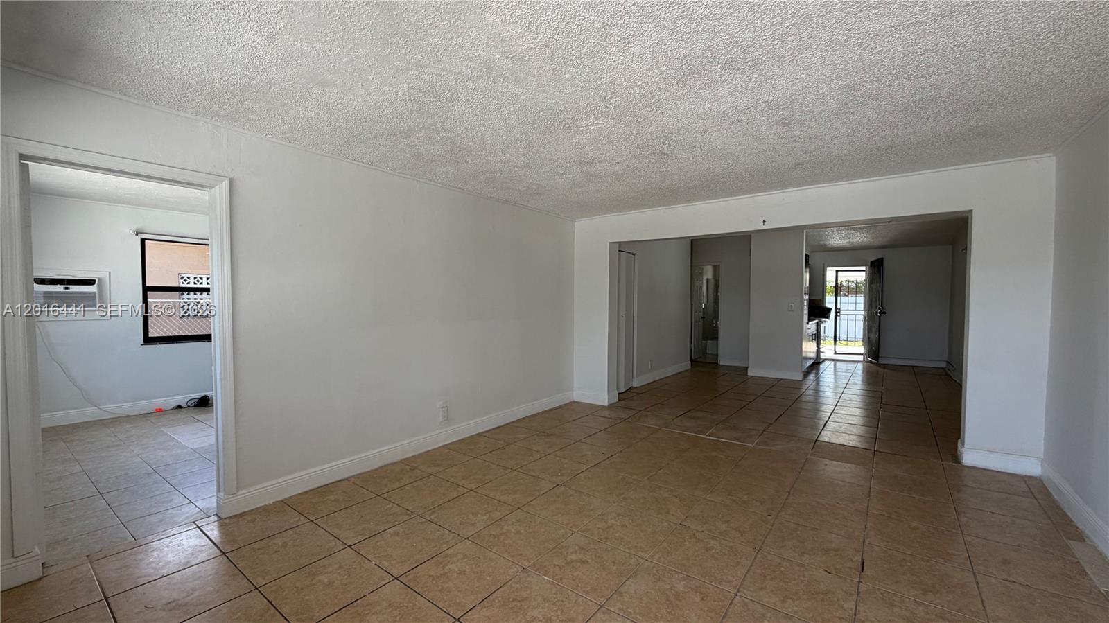 An interior view shows a living area with tile flooring and white walls — 2230 Service Rd, Opa-Locka FL 33054, OPA-LOCKA, FL