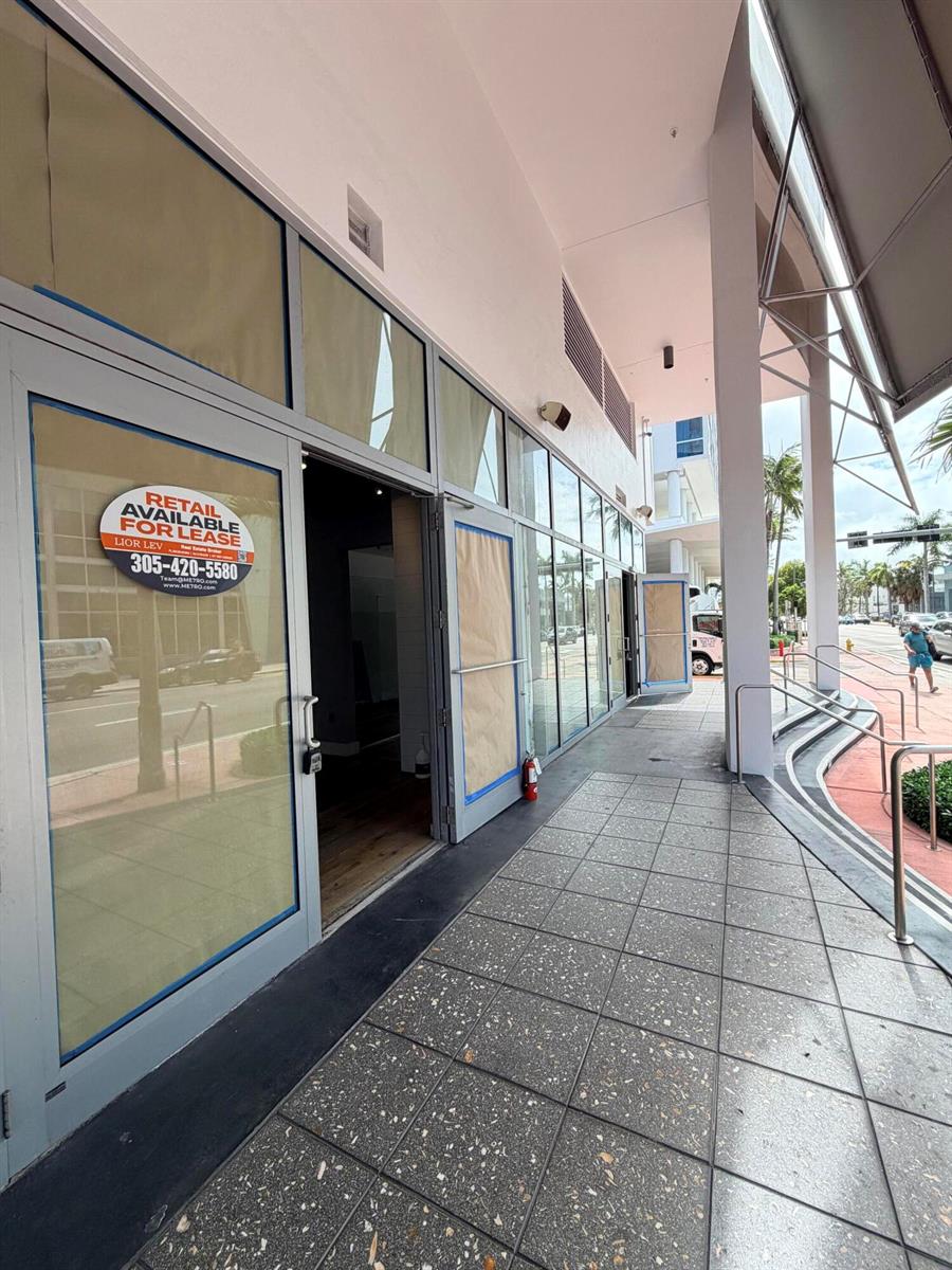 A vacant retail storefront with glass doors and windows sits along a tiled outdoor walkway — 6801 Collins Avenue # 1215, Miami Beach FL 33141, MIAMI BEACH, FL