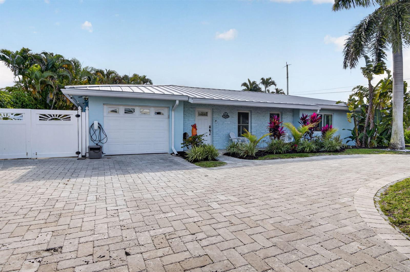 A light blue, single-story house with a metal roof and a paved driveway — 5800 NE 7th Avenue, Boca Raton FL 33487, BOCA RATON, FL